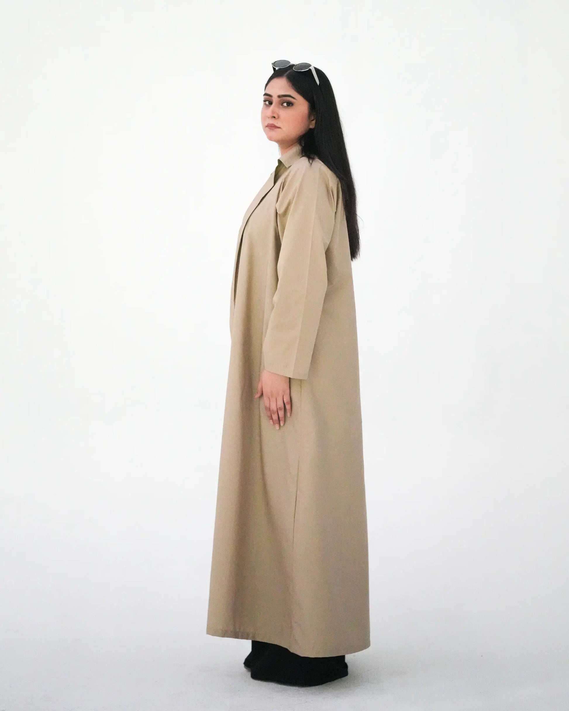 Side profile of beige open abaya with structured modest silhouette